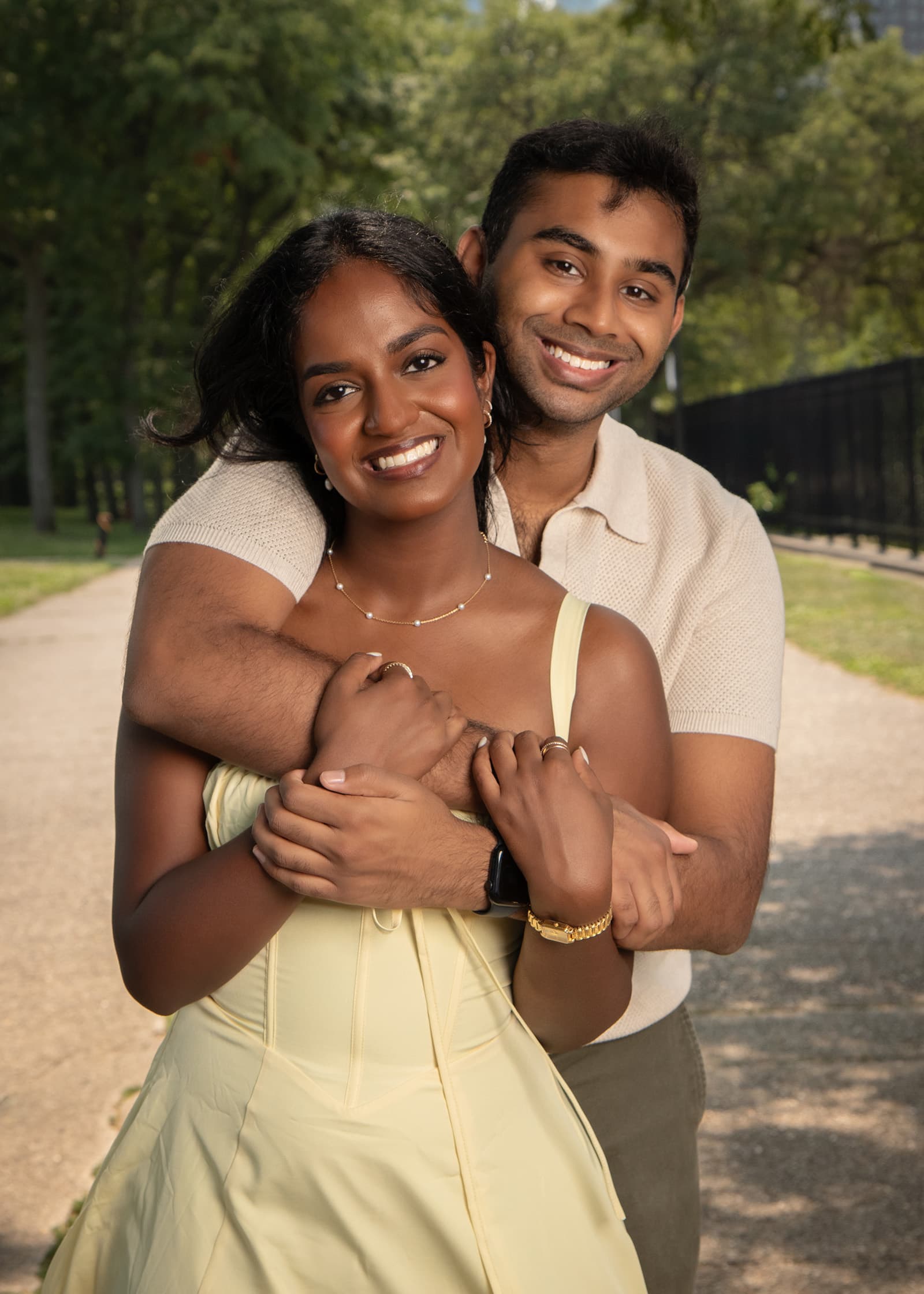 Smiling couple embracing during a relaxed outdoor portrait session with warm natural light and a leafy Tampa Bay setting.