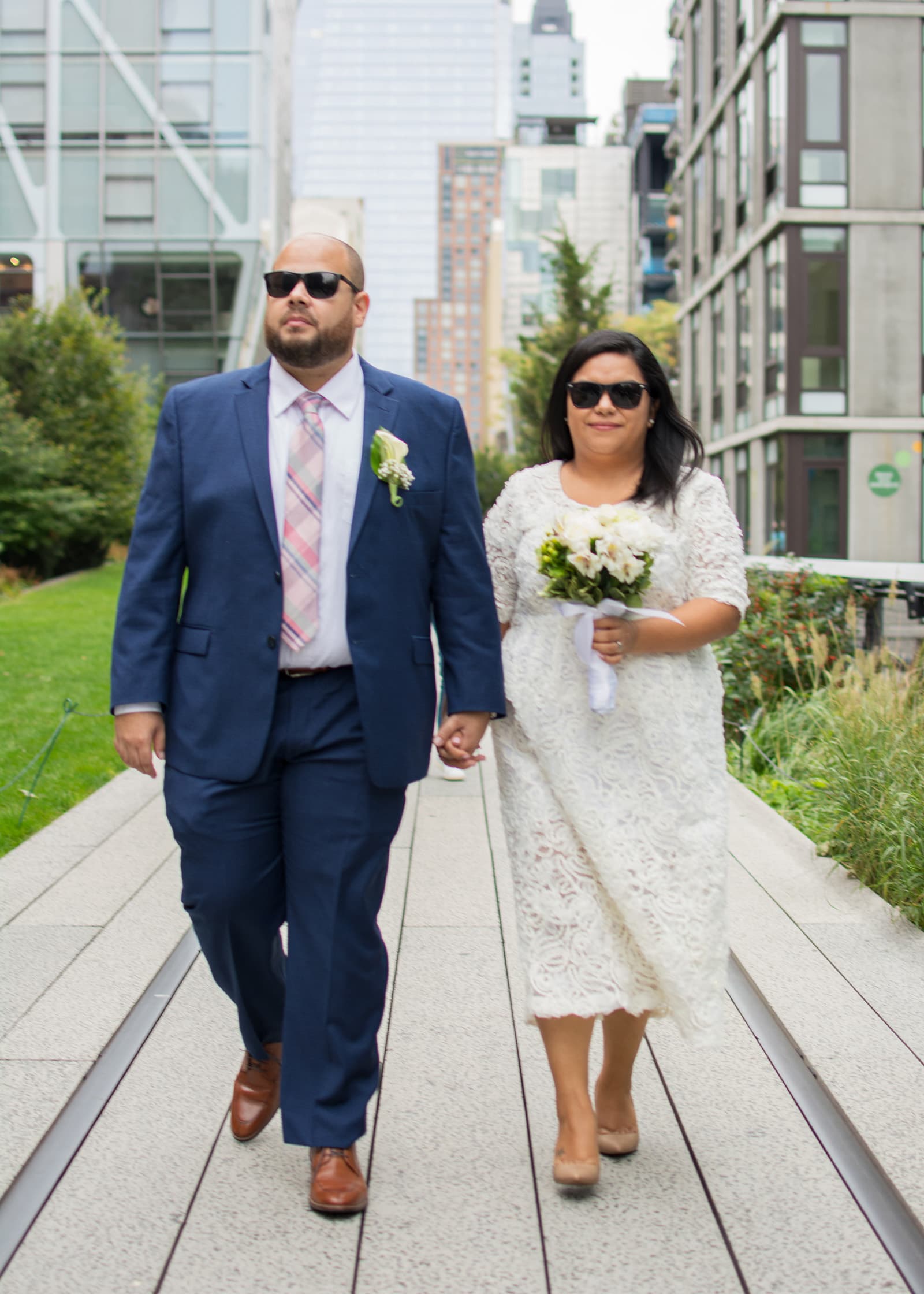 Elopement couple walking hand in hand through an urban park setting, photographed during relaxed Tampa Bay portrait session.