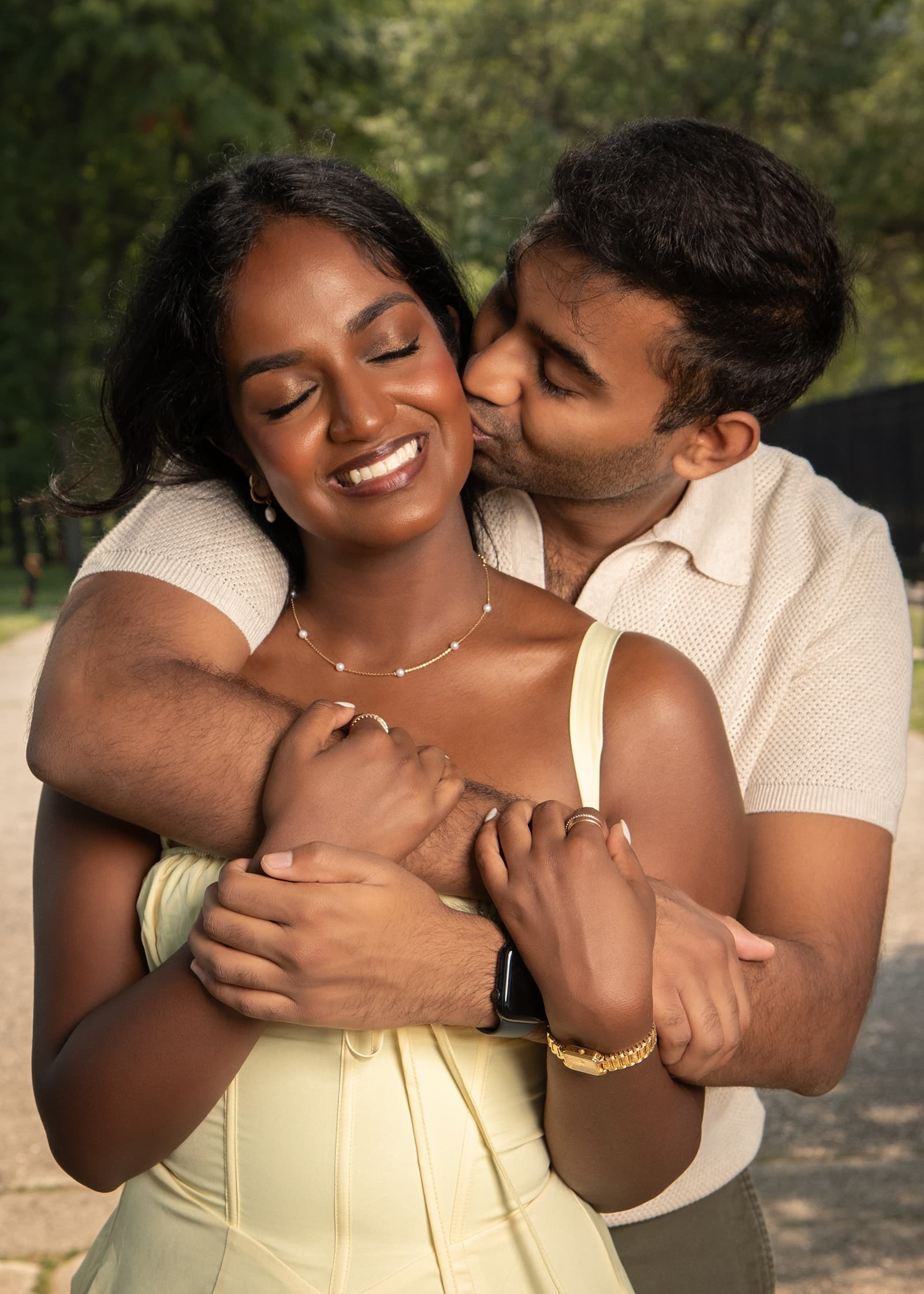 Man kissing his partner on the cheek as she smiles during an affectionate outdoor couples portrait session in Tampa Bay.
