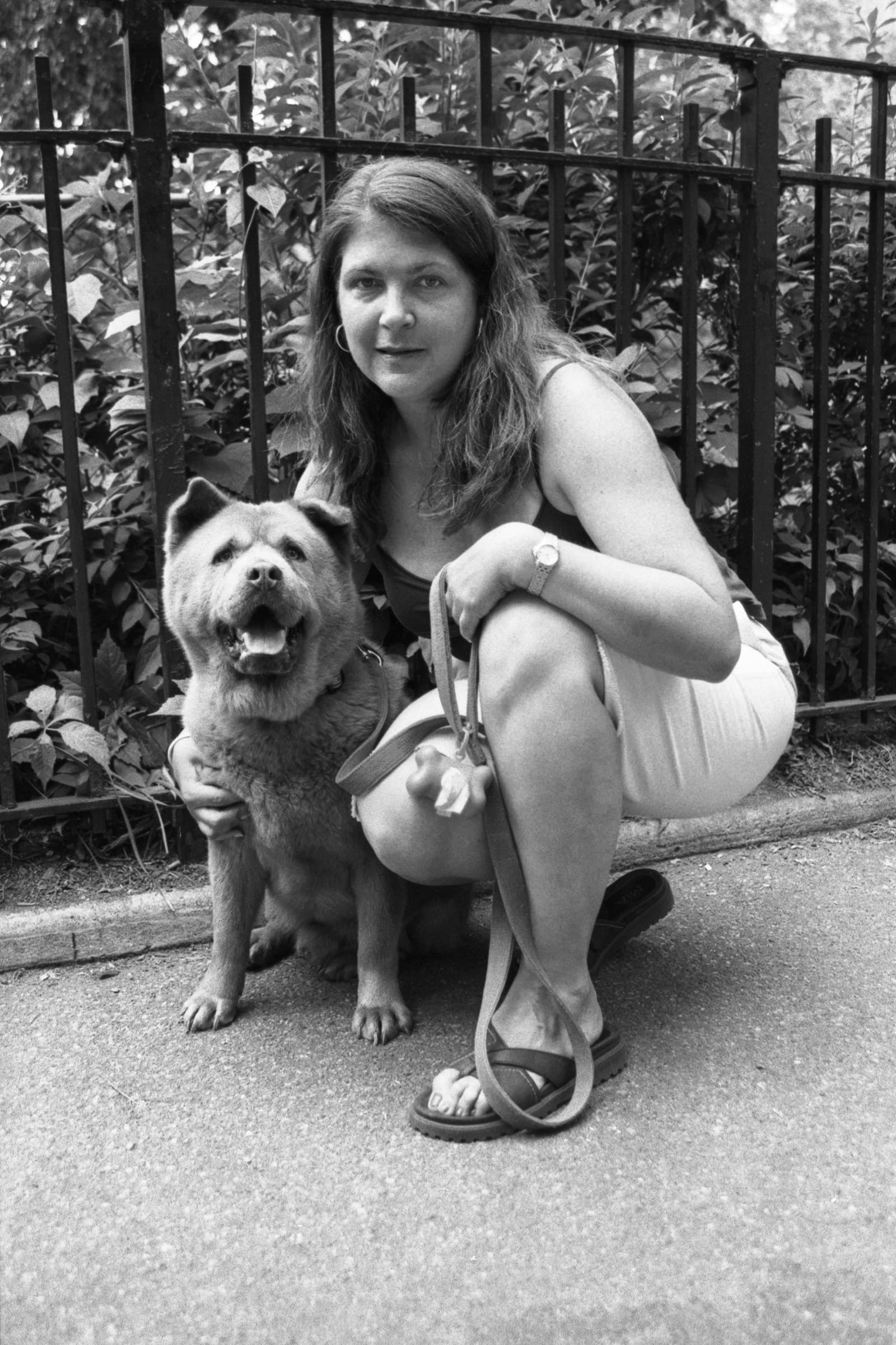 Woman crouches beside her Chow Chow for a relaxed black-and-white dog and owner portrait photographed in a Tampa park.