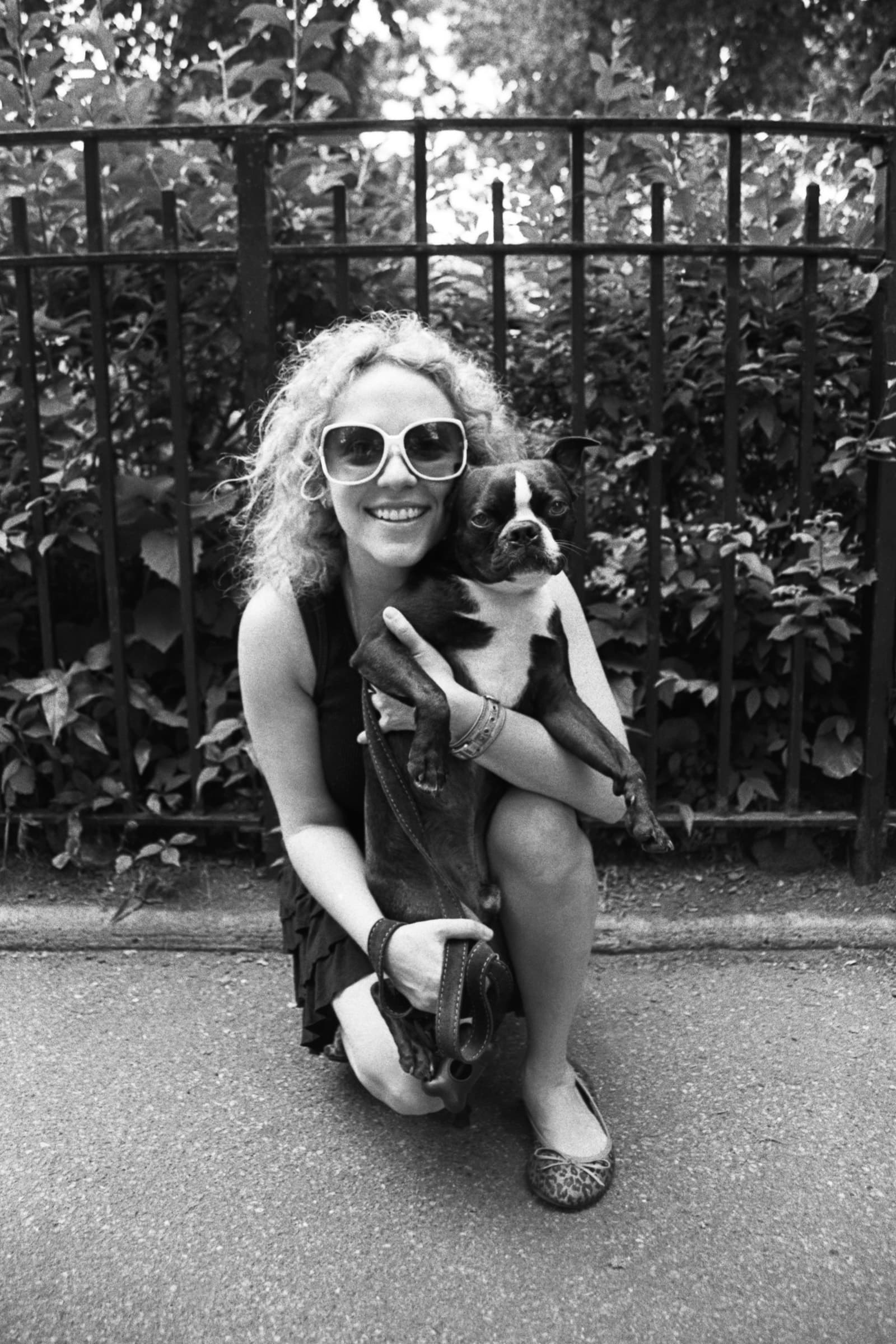 Woman smiling with her Boston Terrier during a black-and-white Tampa dog photography portrait session in a local park.