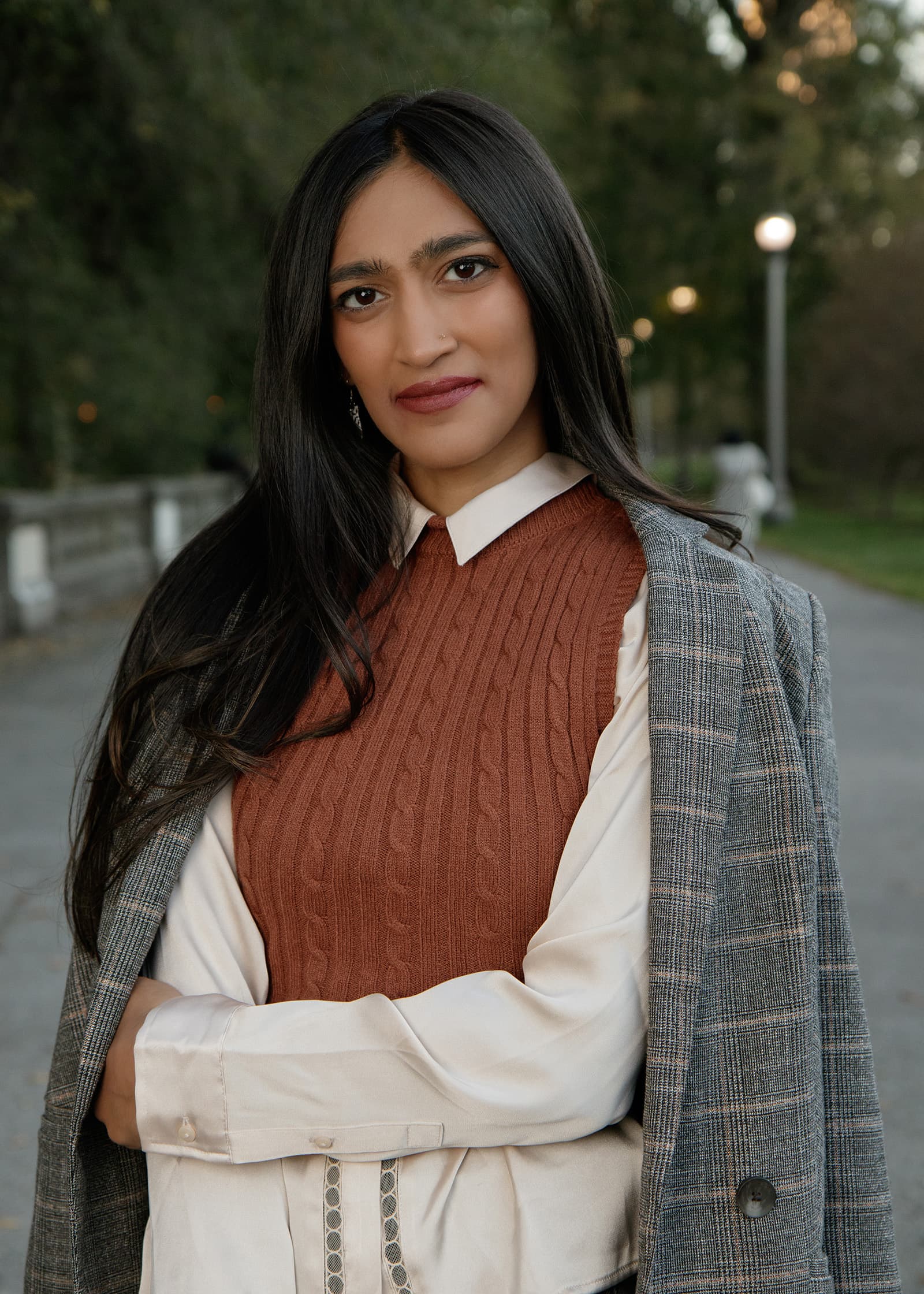 Business portrait of a woman with folded arms in layered professional attire, photographed outdoors in Tampa Bay.