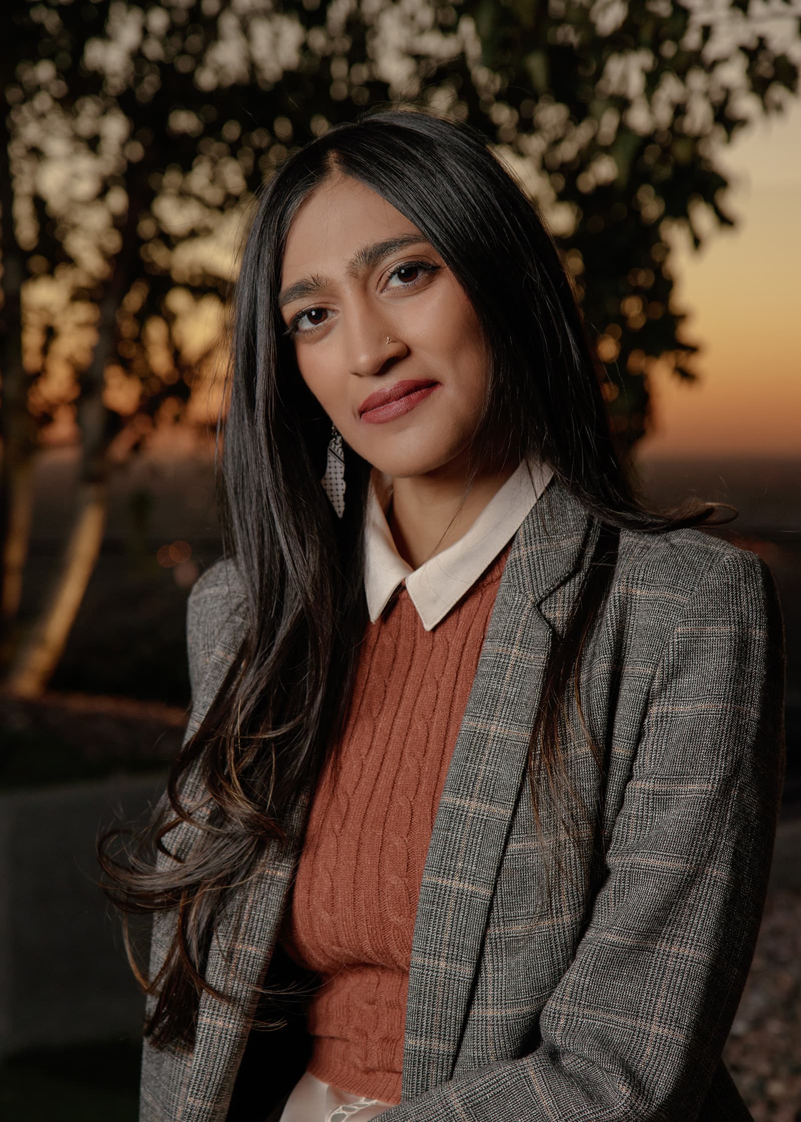 Editorial portrait of a professional woman in a plaid blazer photographed at sunset in the Tampa Bay area.