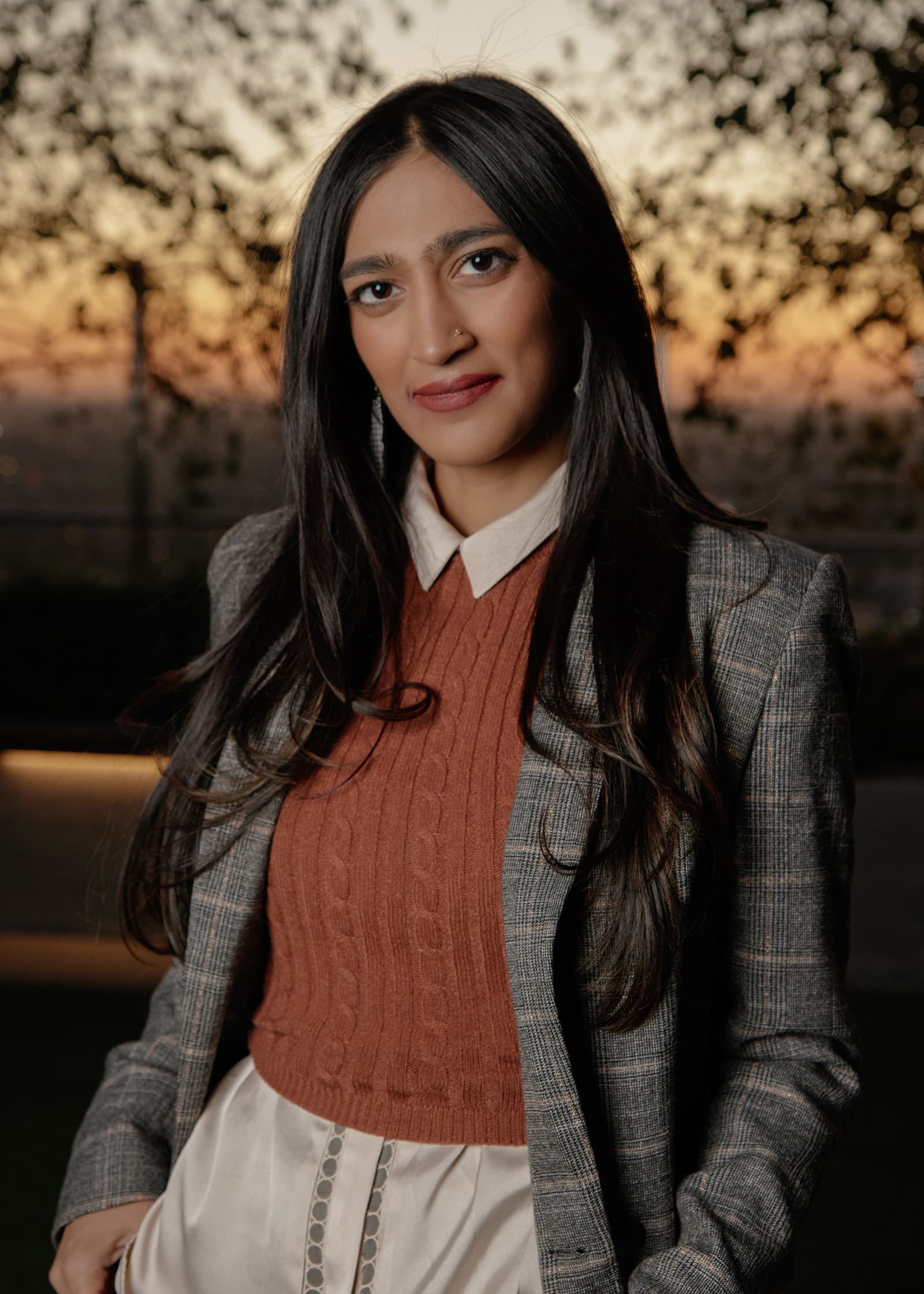Professional sunset portrait of a woman in a plaid blazer with warm evening light in the Tampa Bay area.