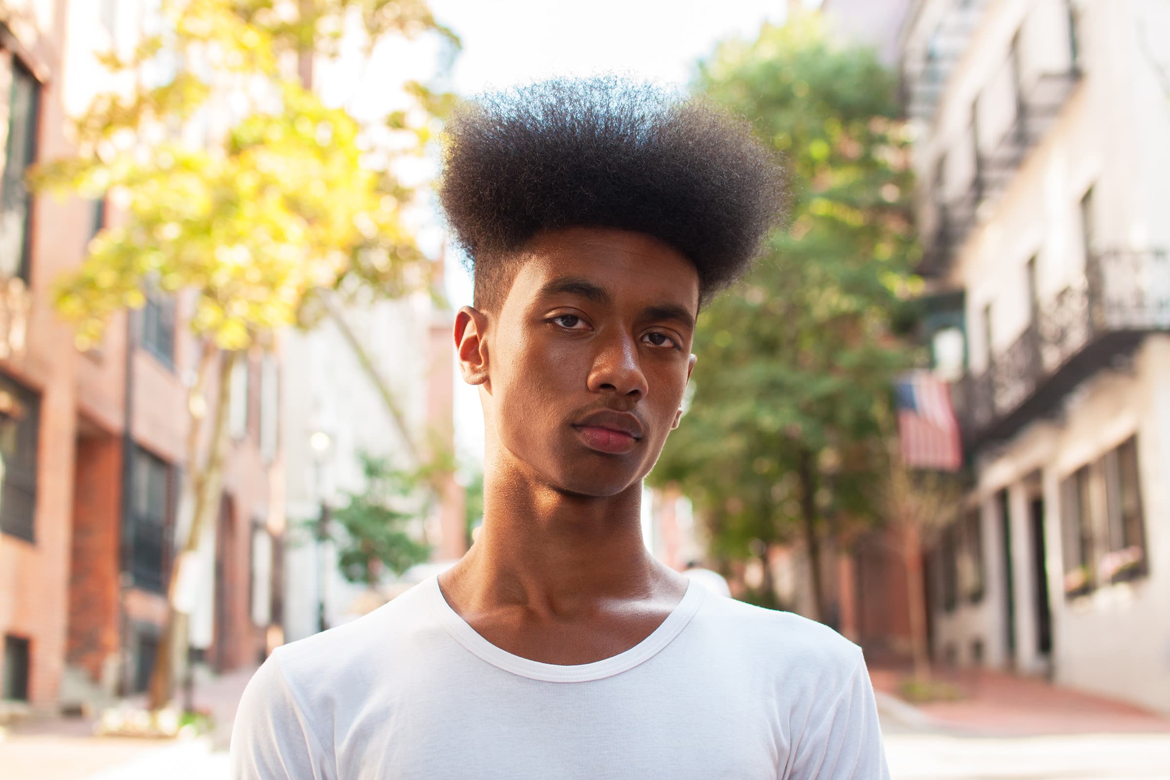 Outdoor professional headshot of a young man in Tampa, photographed on a city street with warm natural light.